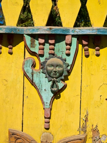 Colourful yellow door with brass knocker